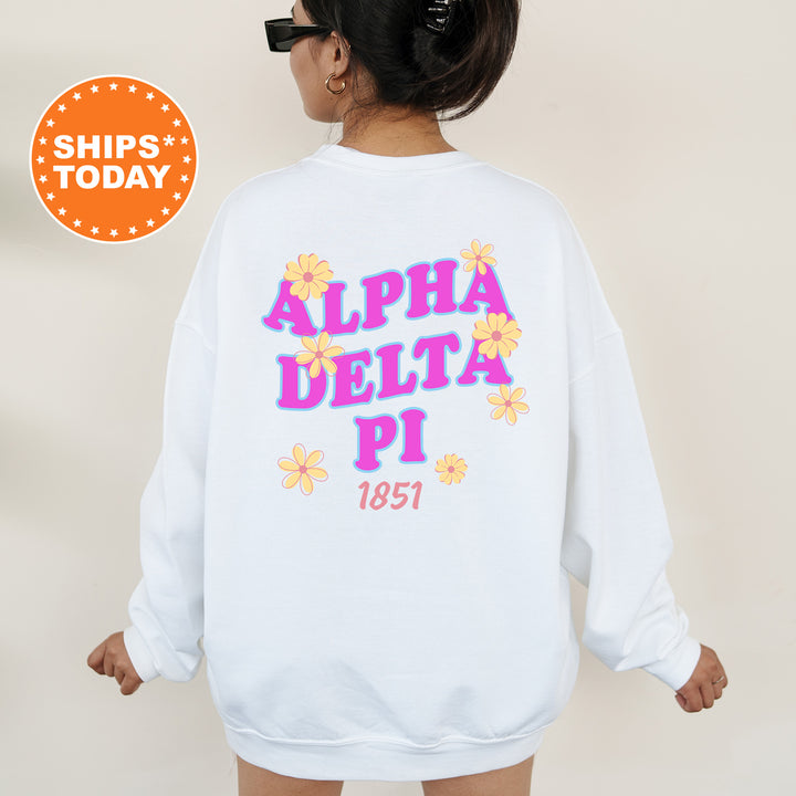 A person wearing a white sweatshirt with the text "ALPHA DELTA PI 1851" printed on it.