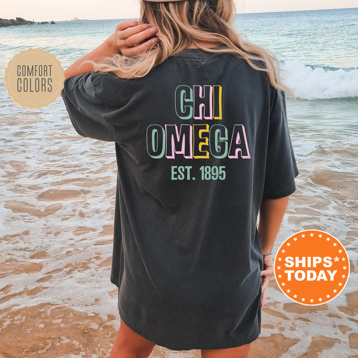 a woman standing on a beach wearing a black shirt