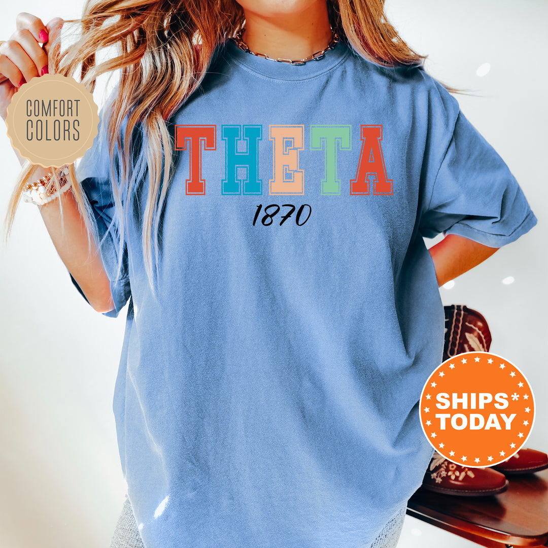 a woman wearing a blue t - shirt with the word thea printed on it