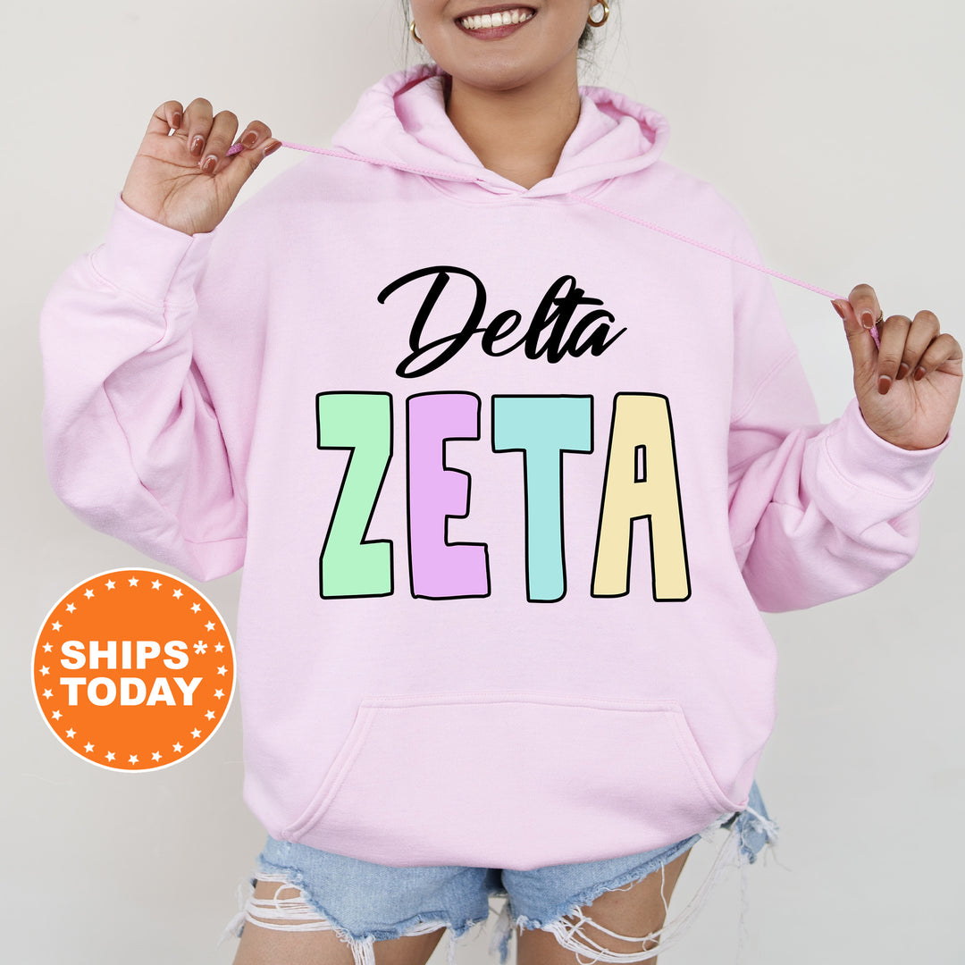 a woman wearing a pink hoodie that says delta zeta