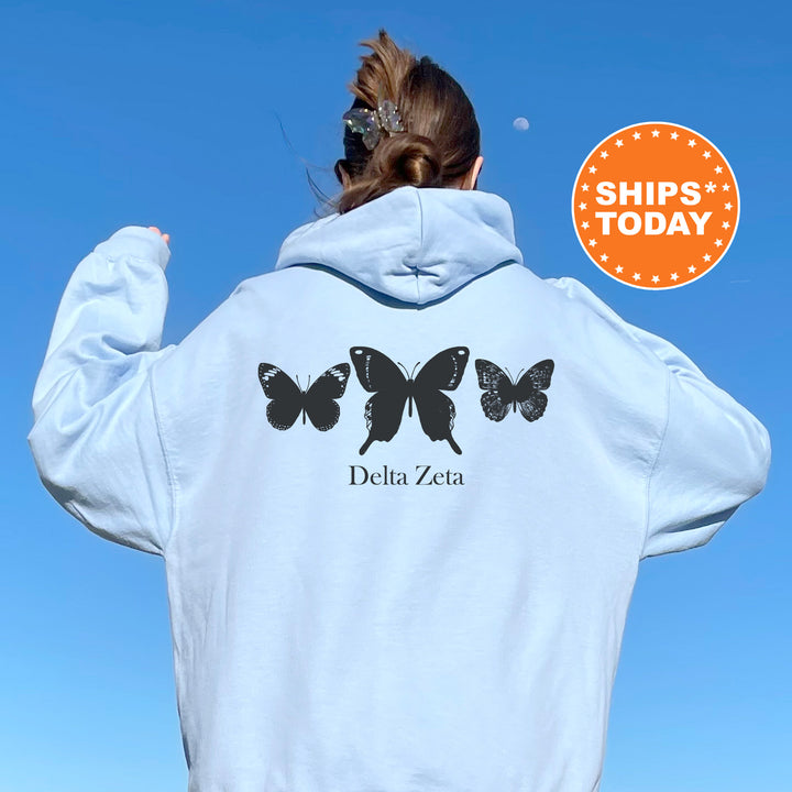 a woman wearing a white hoodie with butterflies on it