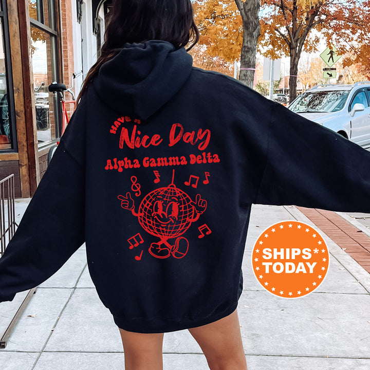 a woman walking down a sidewalk wearing a black hoodie