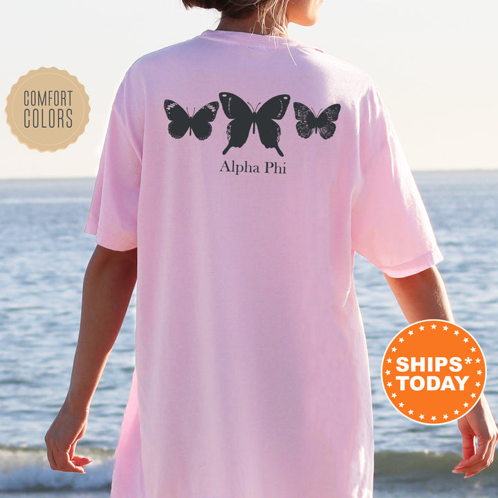 a woman wearing a pink shirt with butterflies on it