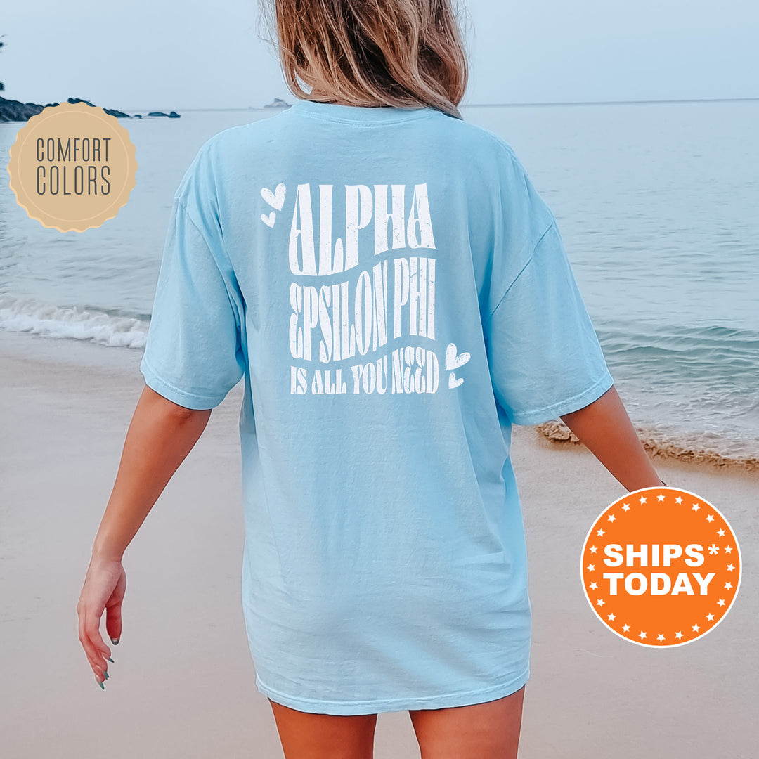 a woman walking on the beach wearing a blue shirt