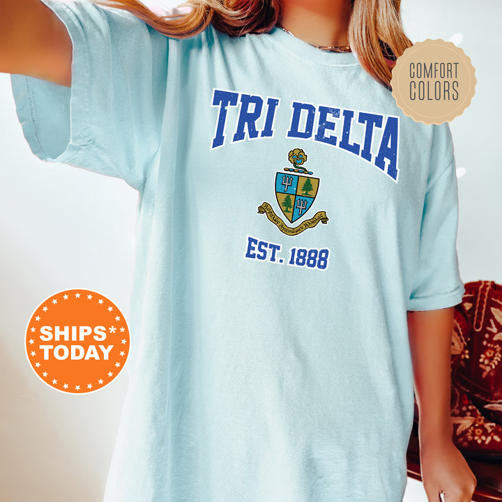 a woman wearing a blue t - shirt with the words tri delta on it