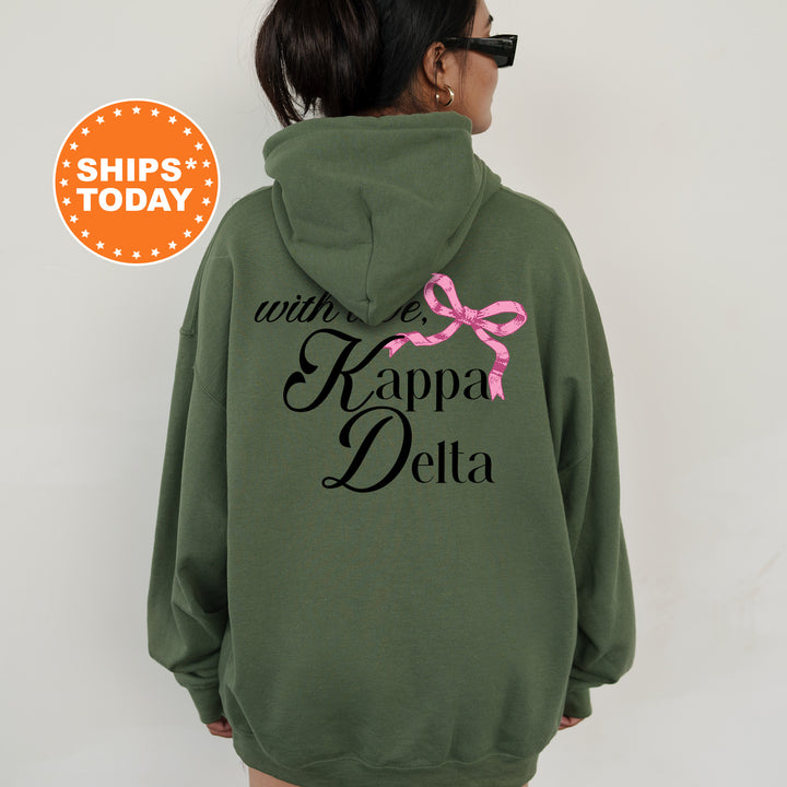 a woman wearing a green hoodie with a pink bow