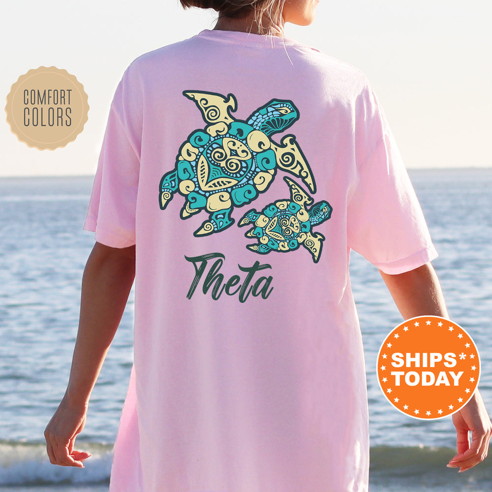 A person wearing a pink t-shirt with a design of two stylized turtles, one larger and one smaller, on the back.