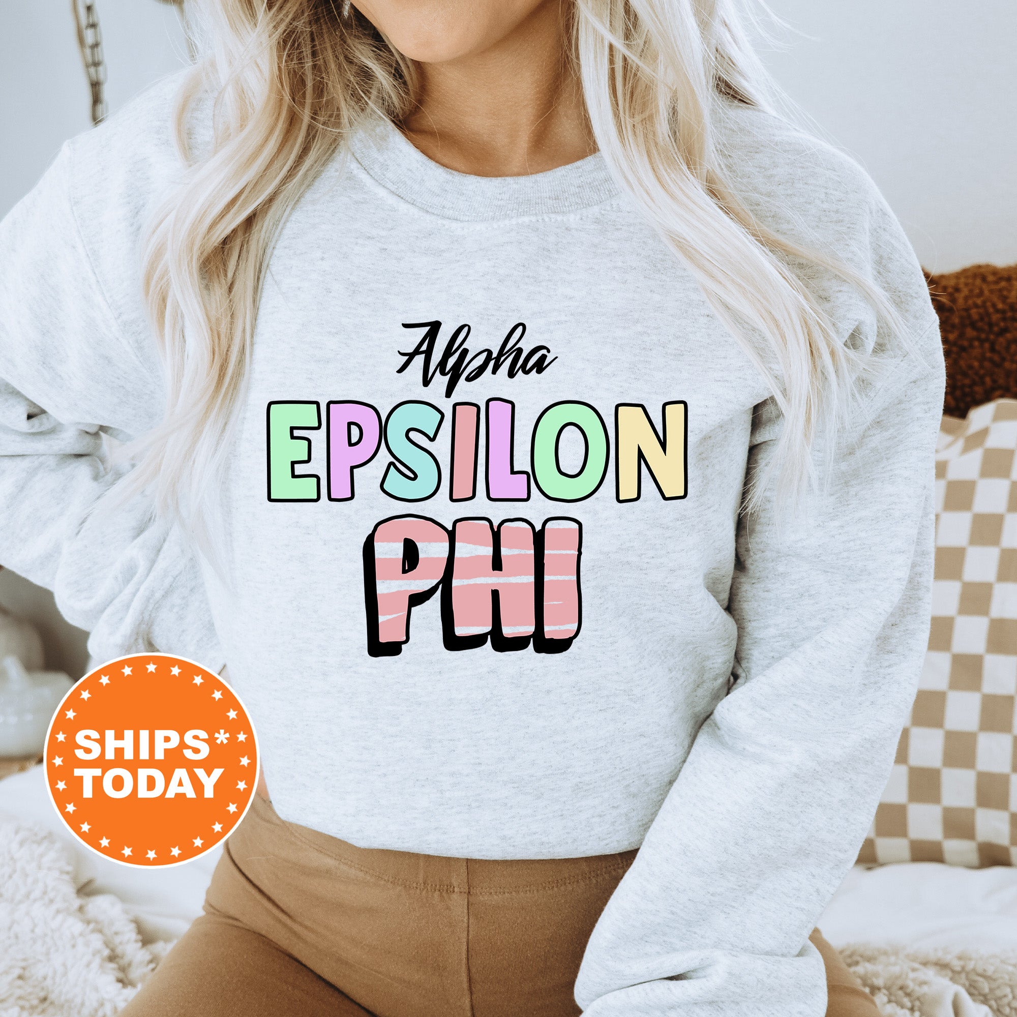 a woman wearing a white sweatshirt with the words epision phi on it