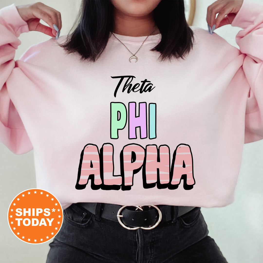 a woman wearing a pink sweatshirt with the words, thea phi alpha on