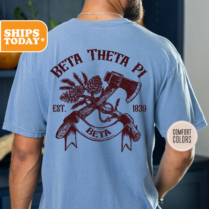 a man wearing a t - shirt with a hammer and a pine cone on it