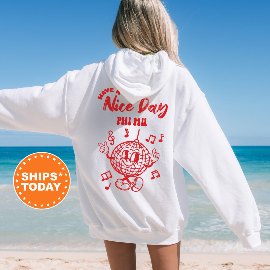 a woman standing on a beach wearing a white sweatshirt