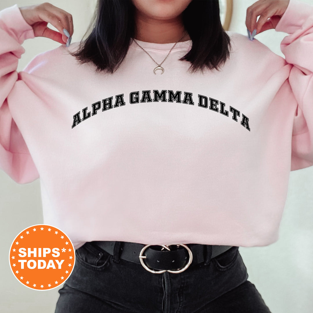 a woman wearing a pink sweatshirt with the words albia gama delta on it