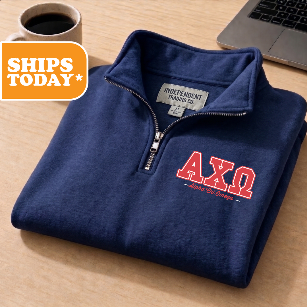 A navy blue zip-up jacket with the text "AXQ" printed on the front, placed on a wooden surface next to a laptop and a coffee cup.