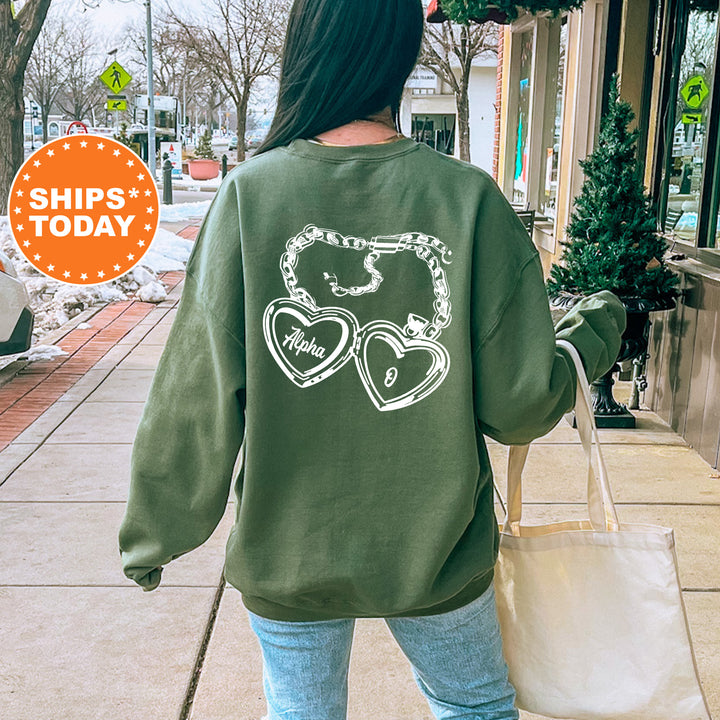 A person wearing a green sweatshirt with a graphic design on the back is walking down a sidewalk, carrying a white bag.