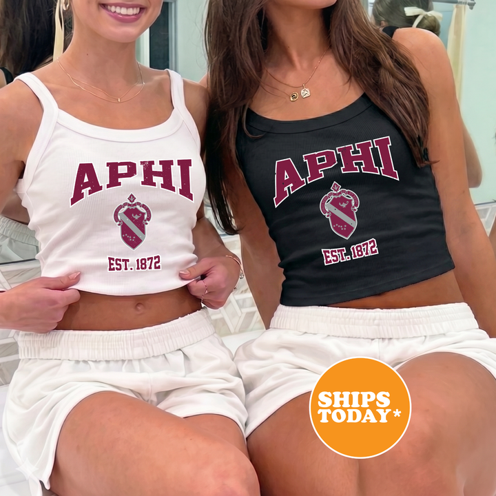 Two women wearing tank tops with the letters "APHI" printed on them, posing together.