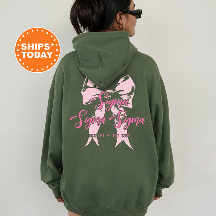 a woman wearing a green hoodie with a pink ribbon on it