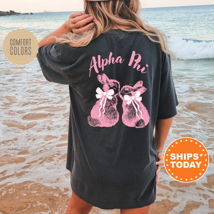 a woman standing on a beach wearing a black shirt