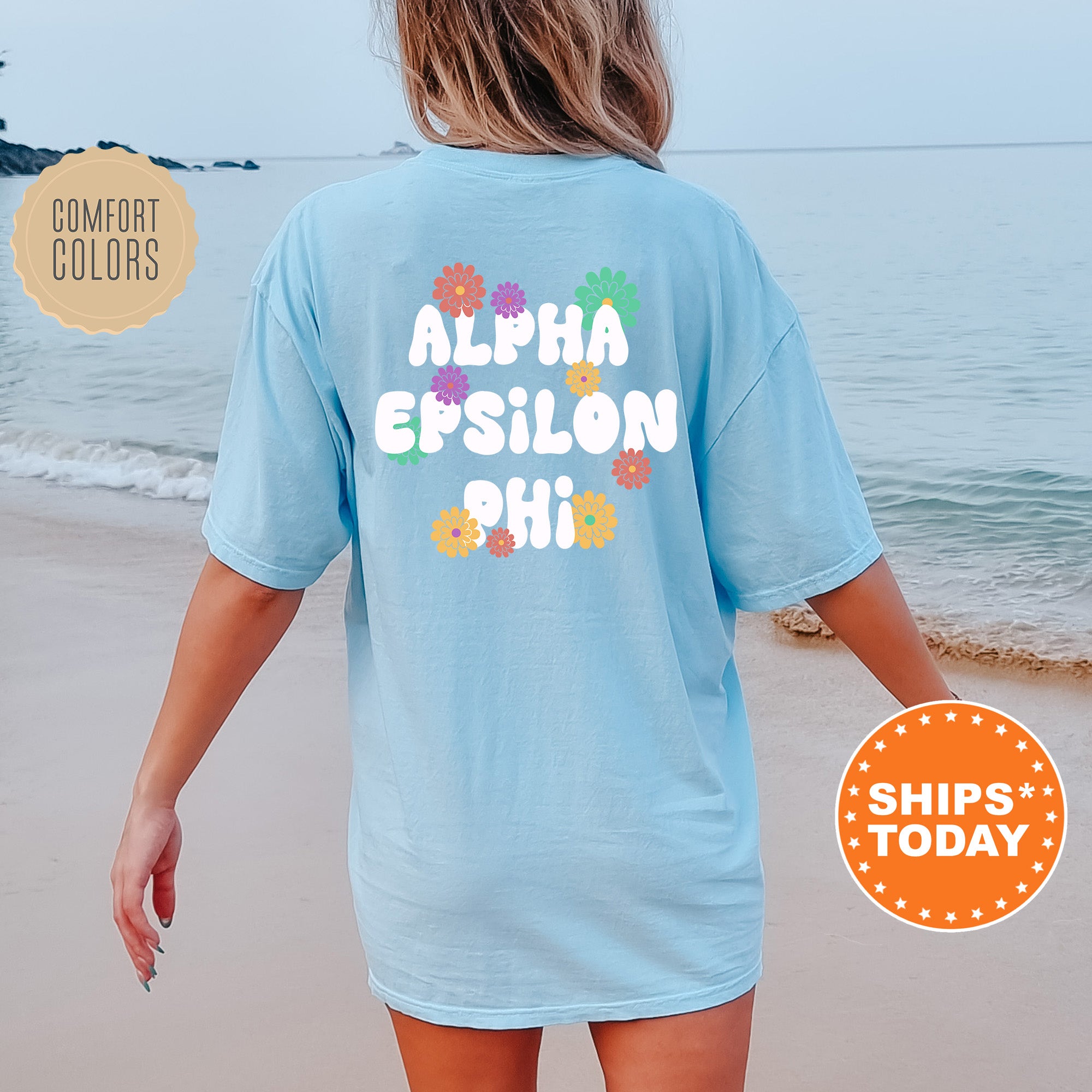 a woman walking on the beach wearing a blue shirt