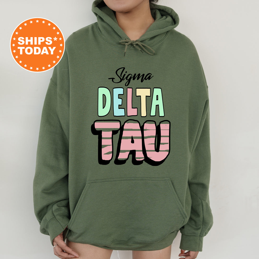 a woman wearing a green hoodie with the words delta tau on it