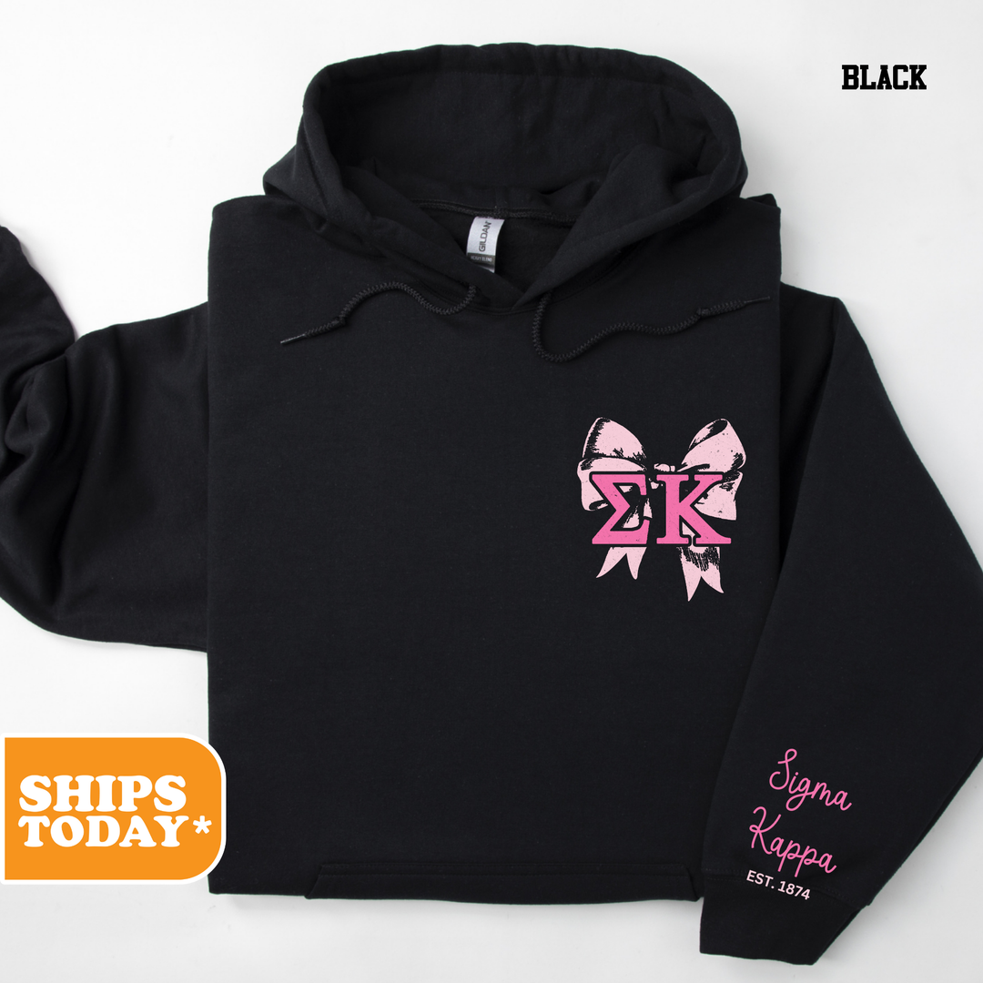 a black hoodie with a pink bow on it