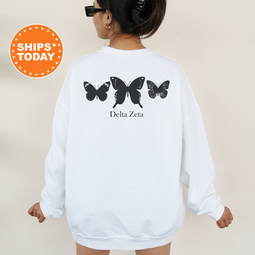 a woman wearing a white sweatshirt with butterflies on it