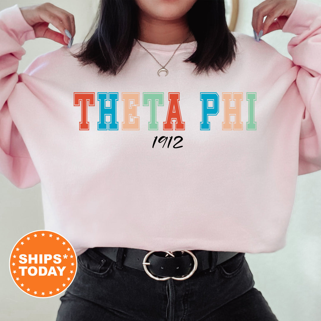 a woman wearing a pink sweatshirt with the word'thea phi'printed on