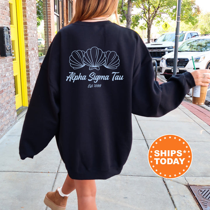 A person wearing a black sweatshirt with the text "Alpha Sigma Tau" printed on it, walking down a sidewalk.