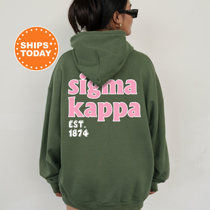 A person wearing a green hoodie with pink text and numbers on the back.
