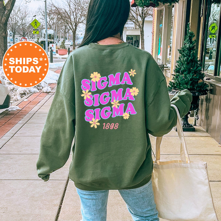 A person wearing a green sweatshirt with the text "SIGMA SIGMA SIGMA" printed on it, walking down a city street.