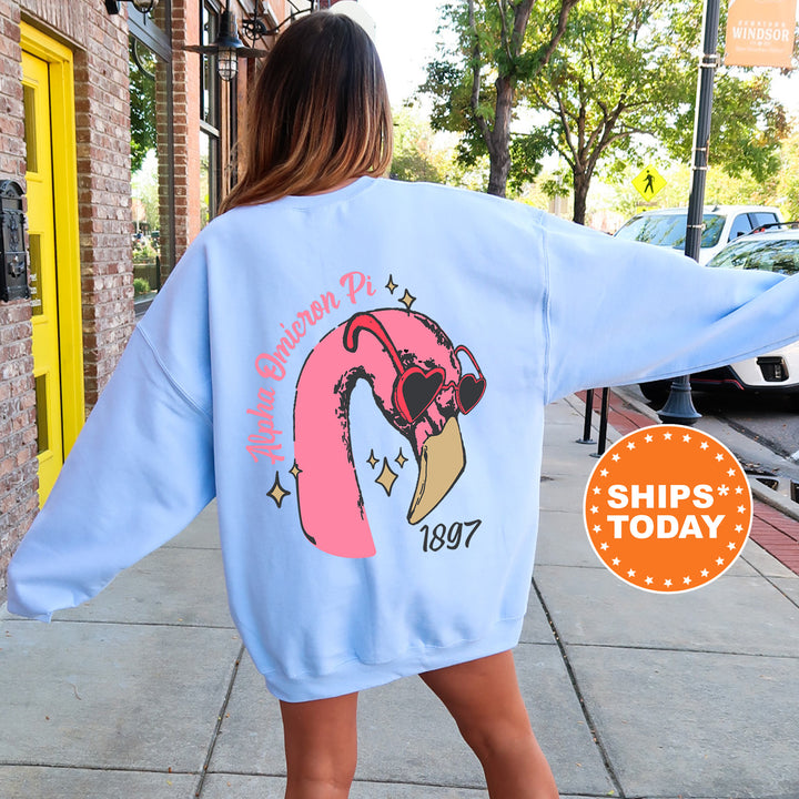 a woman walking down a sidewalk wearing a pink flamingo sweatshirt