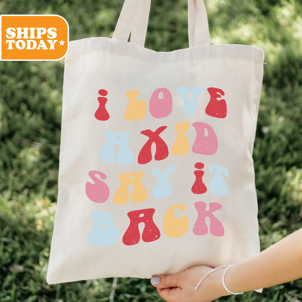 a person holding a tote bag with the words joy and skis on it