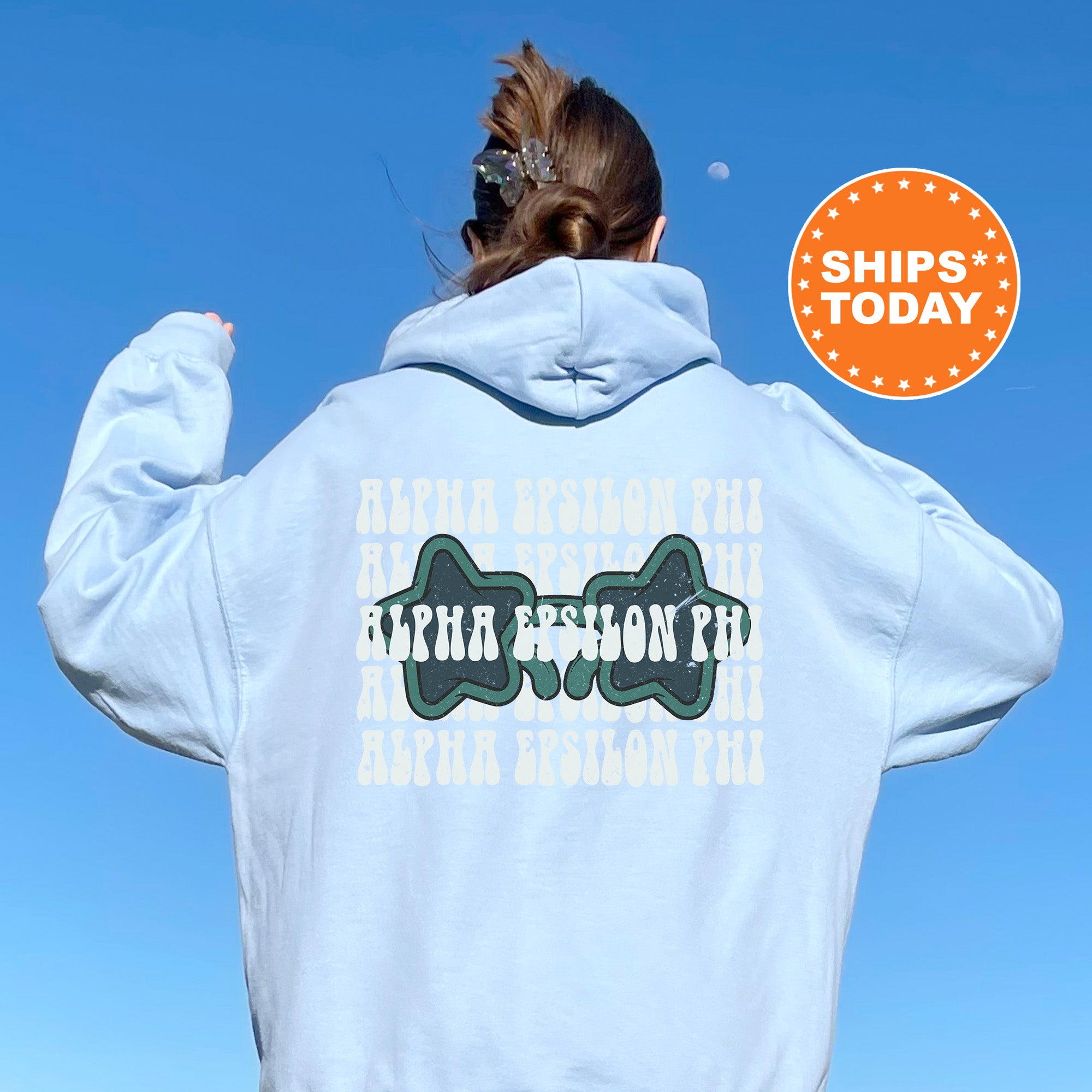 a woman wearing a white hoodie with a blue sky in the background