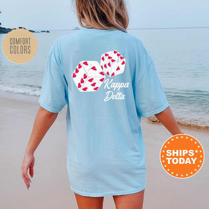 a woman walking on the beach wearing a blue shirt