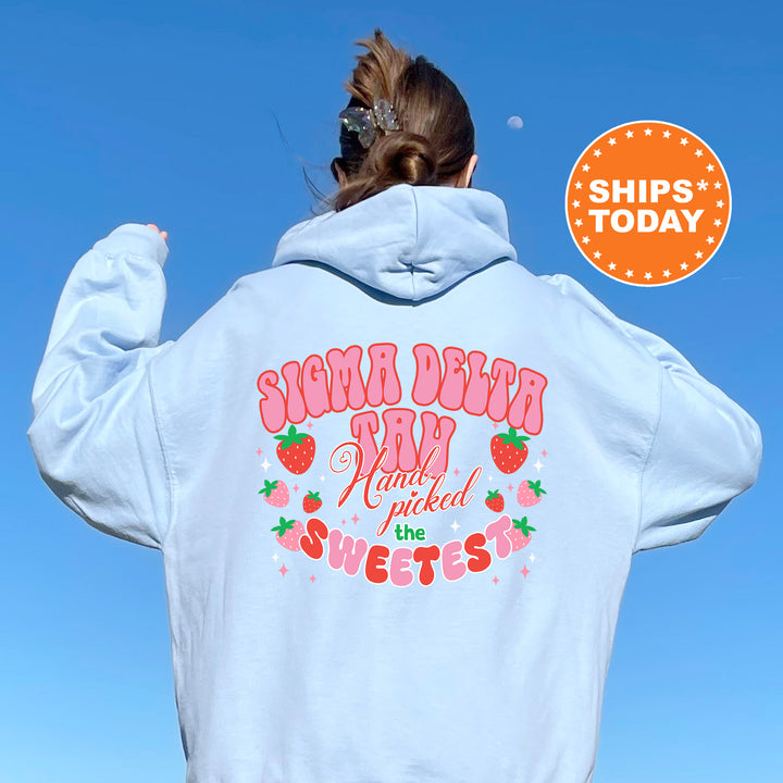 a woman wearing a white hoodie with a strawberry print on it