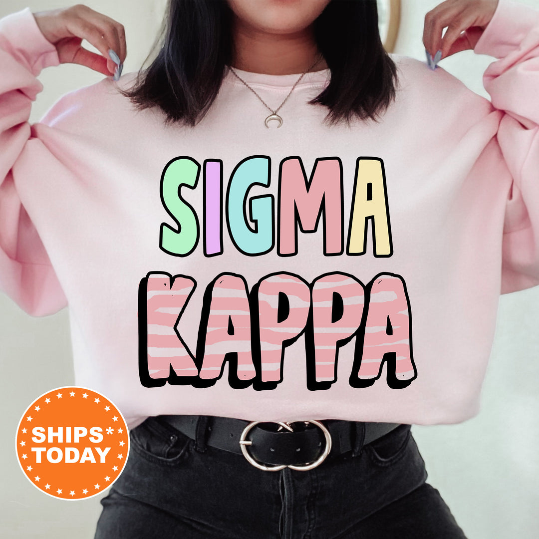 a woman wearing a pink sweater that says stigmaa kappa