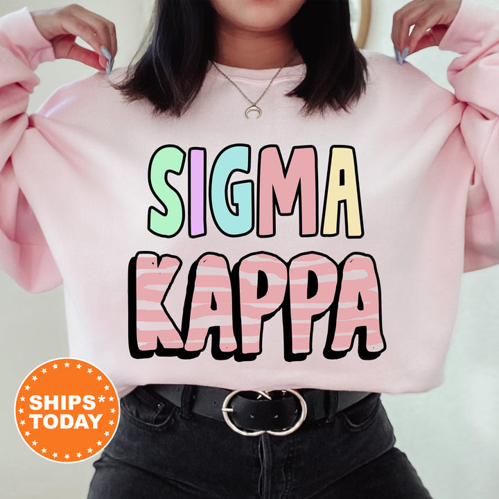 a woman wearing a pink sweater that says stigmaa kappa