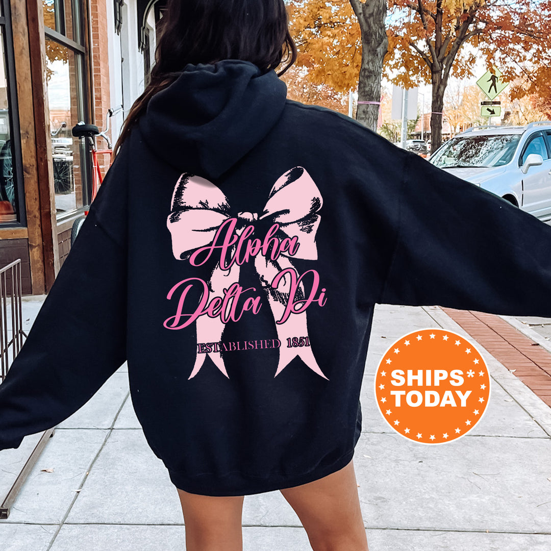 a woman in a black hoodie with a pink bow on it