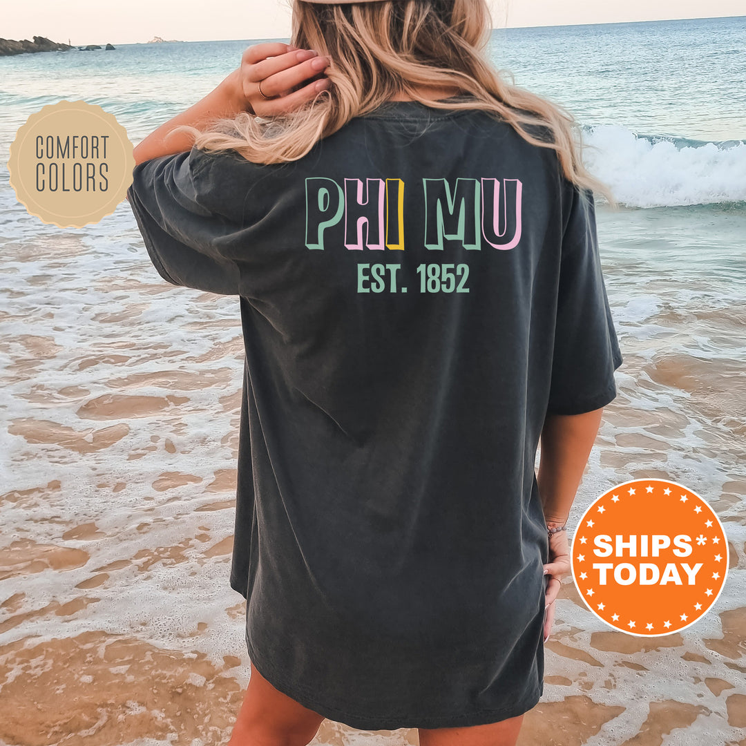 a woman standing on a beach wearing a black shirt