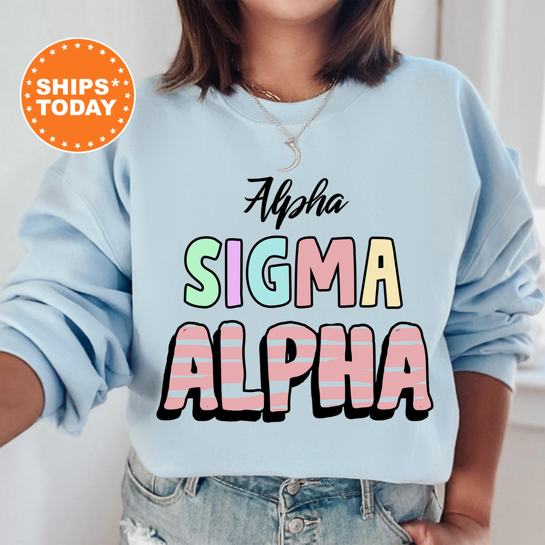 a woman wearing a light blue sweatshirt with the words aloha, sigm