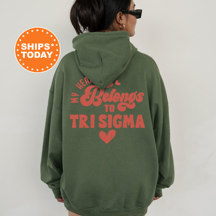 a woman wearing a green hoodie that says we belong to trisima