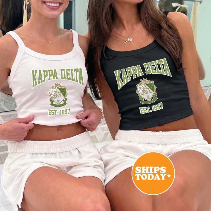 Two women wearing matching white and black tops with the Kappa Delta logo, posing together.