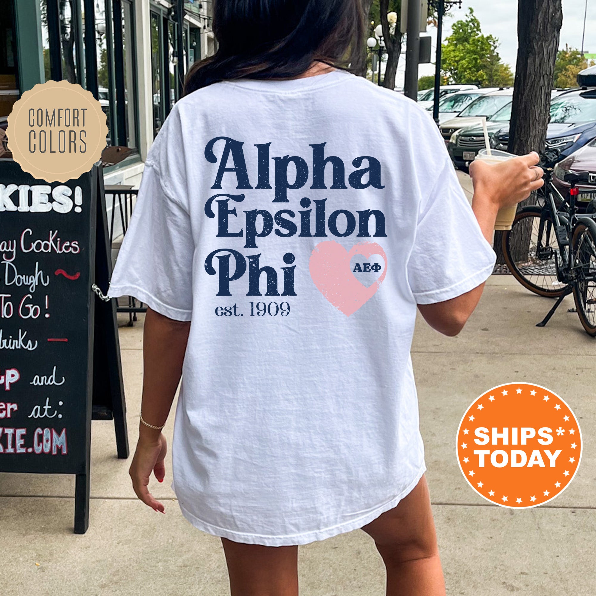 a woman walking down a sidewalk while wearing a white shirt