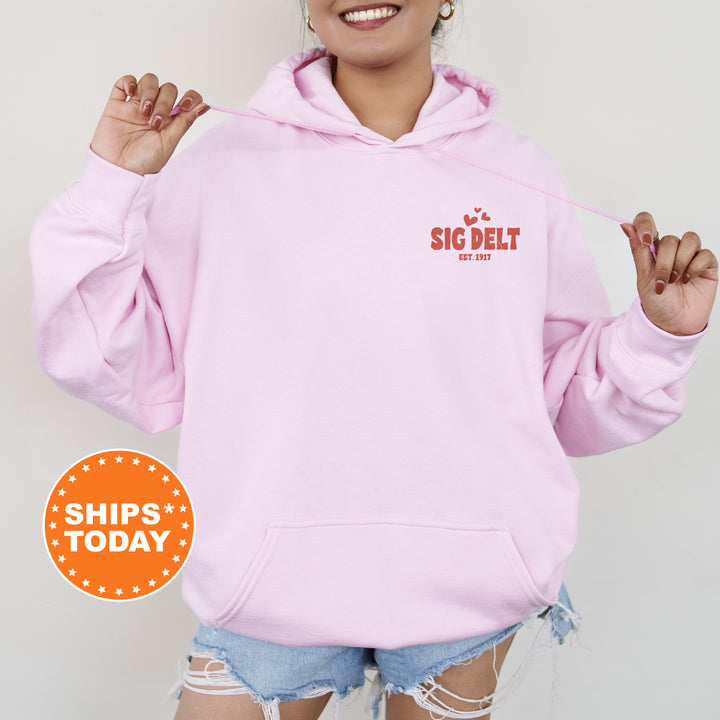 a woman wearing a pink hoodie and ripped shorts