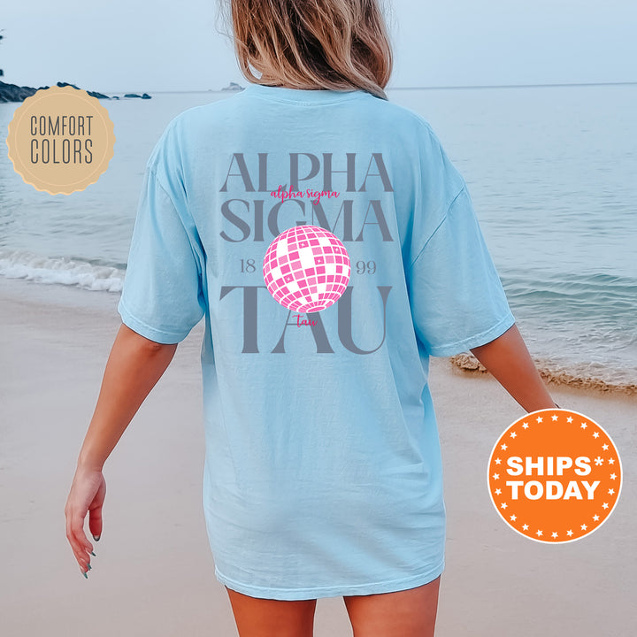 a woman walking on the beach wearing a blue shirt