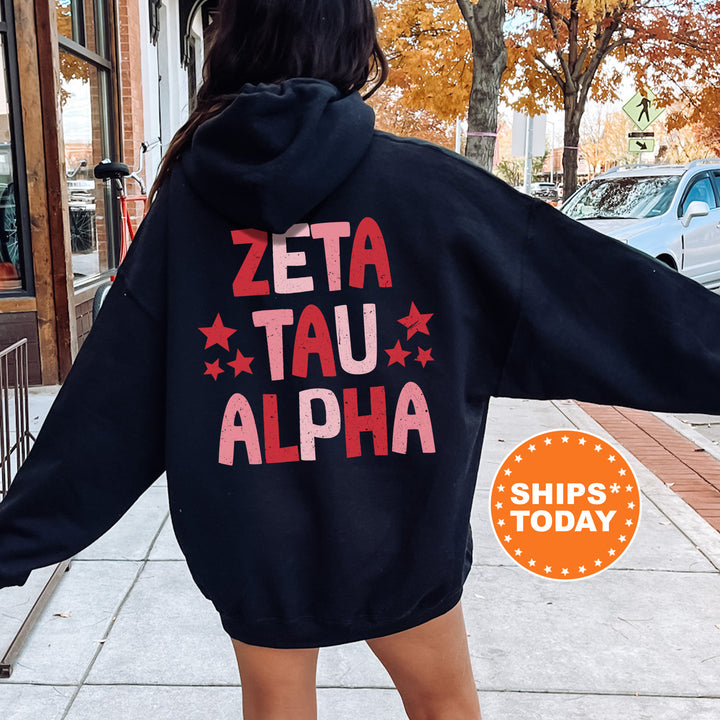 a woman in a black hoodie that says zeta tau alpha