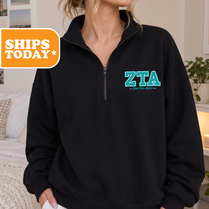 A person wearing a black sweatshirt with the Greek letters 'ZTA' printed on it.