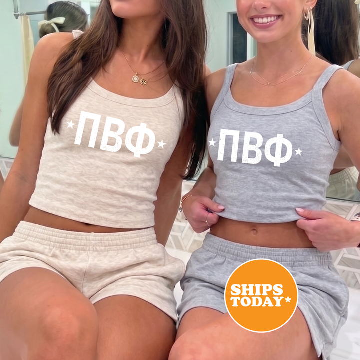 Two women wearing matching tank tops with the letters "ПОВ" printed on them, posing together in front of a mirror.