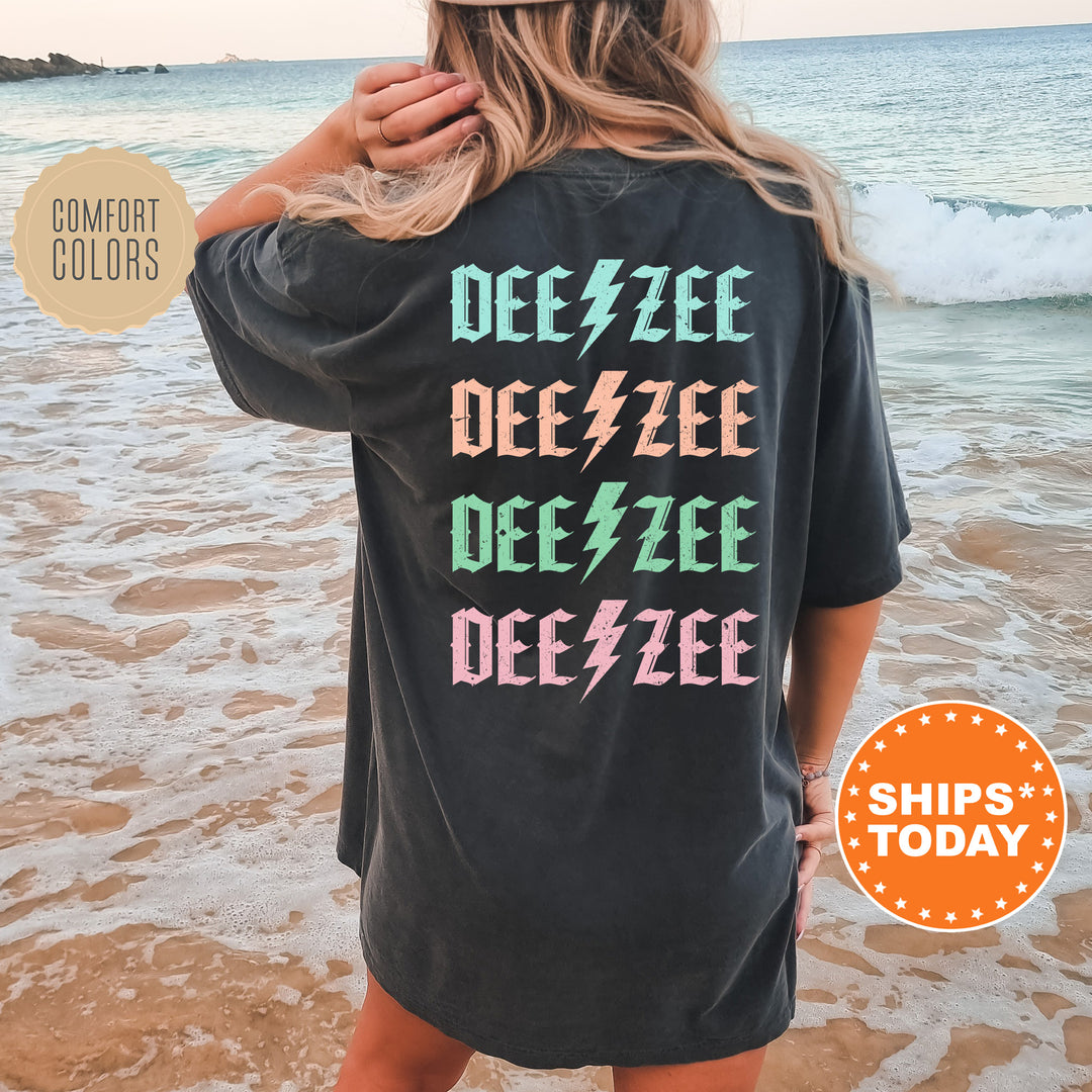 a woman standing on a beach wearing a black tee shirt