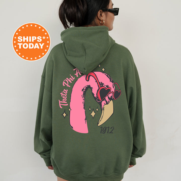 a woman wearing a green hoodie with a pink design on it