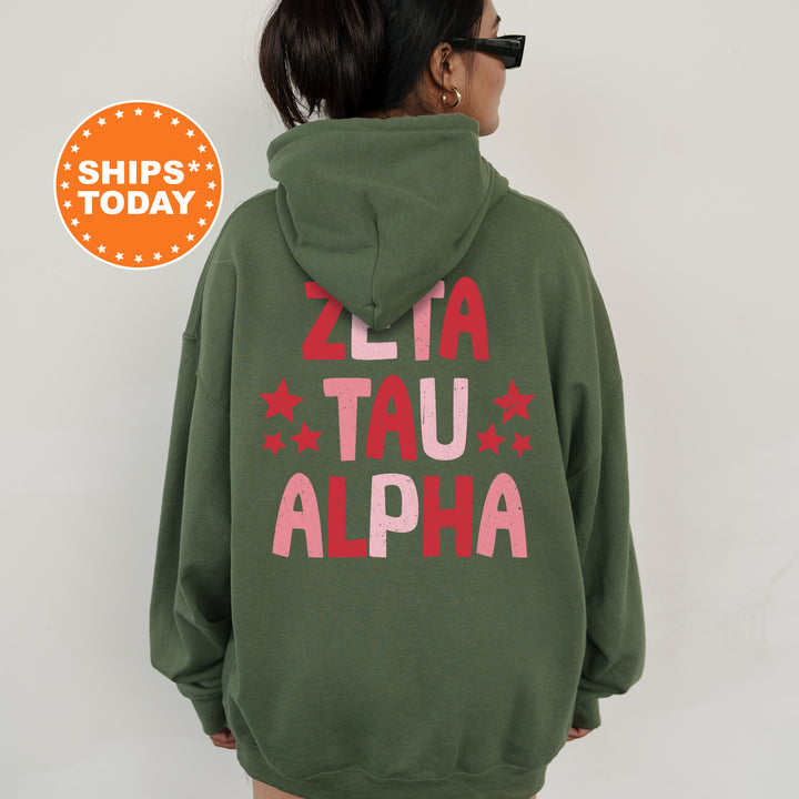 a woman wearing a green hoodie with the words ali tau alpha printed on